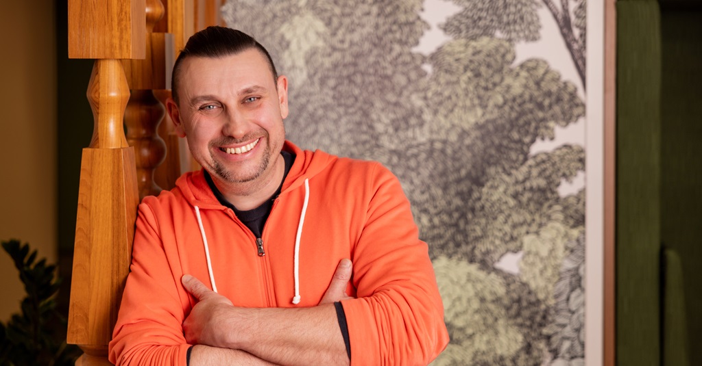 Portrait of a smiling man with arms crossed.