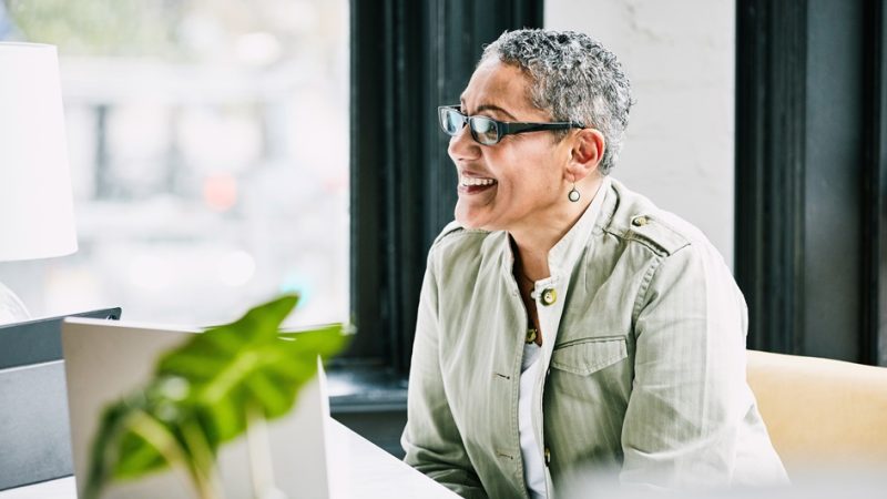 A smiling professional woman at her desk.
