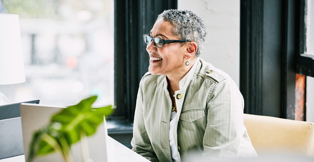 A smiling professional woman at her desk.