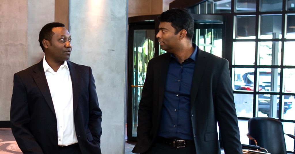 Dos hombres de negocios entrando en el vestíbulo de un hotel.