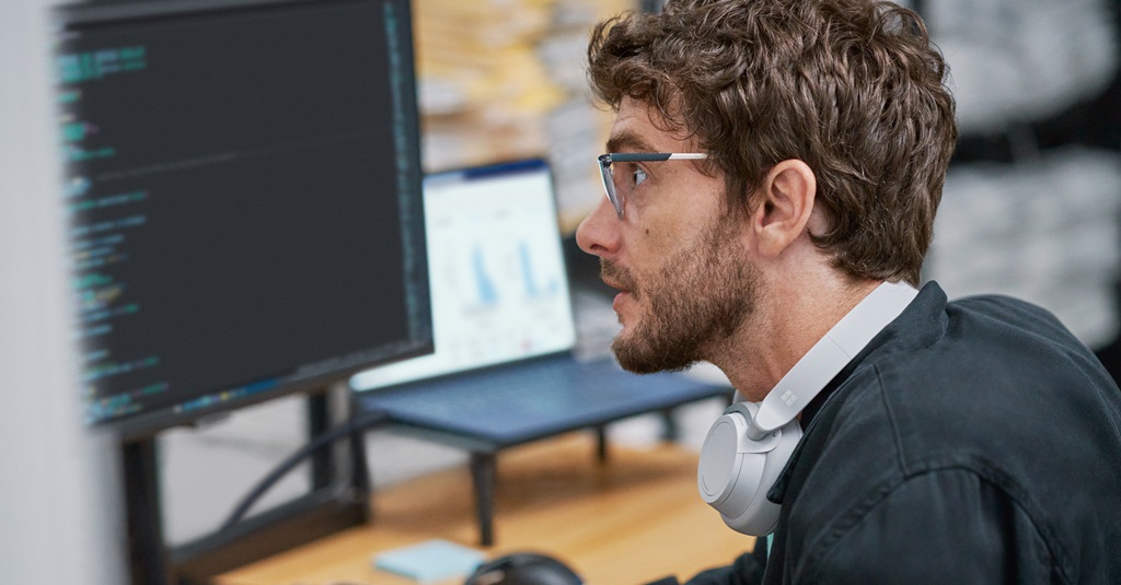 Un joven trabajador de la tecnología mirando el monitor de su computadora.