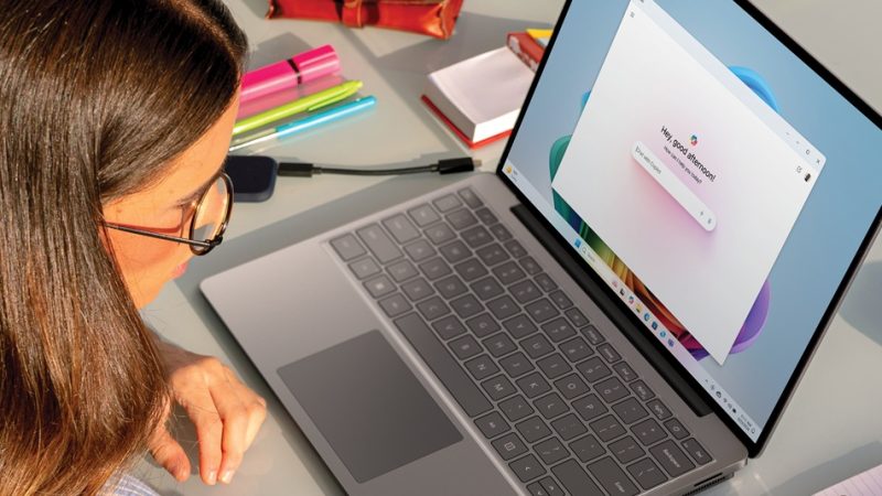 Una mujer joven usando Copilot en su computadora portátil.