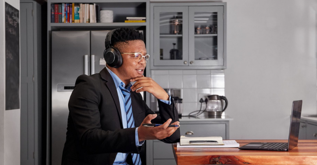 Um homem na frente de um laptop em uma reunião.